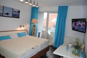 een slaapkamer met een bed en een raam met blauwe gordijnen bij Ferienwohnung Yachthafentraum in Kühlungsborn