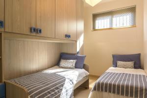 two beds in a small room with cabinets at Casa Lì in Giardini Naxos