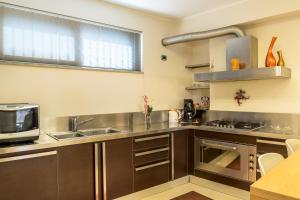 a kitchen with a sink and a microwave at Casa Lì in Giardini Naxos