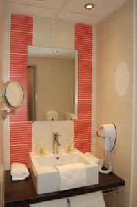 a bathroom with a sink and a mirror at Hôtel Cositel, Coutances in Coutances
