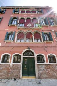 a red brick building with a green door at Palazzo Schiavoni Suite-Apartments in Venice