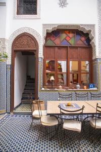 a patio with a table and chairs in a building at Riad Jamaï in Fès