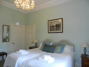 a bedroom with two beds and a chandelier at Brocks in Bath
