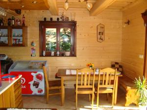 una cucina con tavolo e sedie in una stanza di Rekreačná chata pod Jedľovinou a Varín