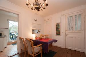 a dining room with a table and chairs and a chandelier at Alster City Garden Villa in Hamburg +35 photos