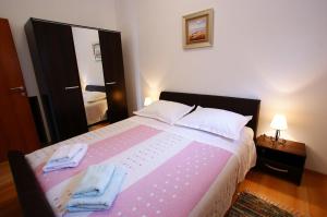 um quarto com uma cama grande com duas toalhas em Apartment Radunić em Kaštela