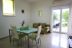 uma sala de estar com uma mesa e cadeiras e um sofá em Apartment Radunić em Kaštela