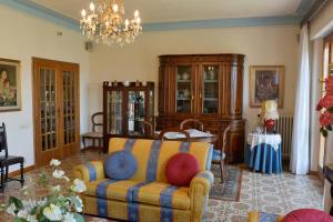 a living room with a couch and a chandelier at Villa La Meridiana in Luciana