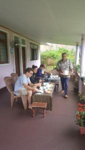 a group of people sitting at tables on a porch at 59B Rest Inn Ella in Ella