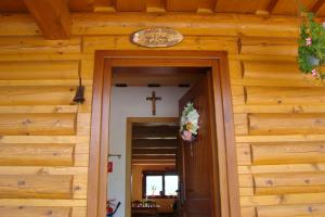 eine Tür zu einer Kirche mit einem Kreuz an der Wand in der Unterkunft Rekreačná chata pod Jedľovinou in Varín