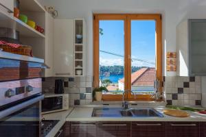 a kitchen with a sink and a large window at Villa Aska in Lopud Island