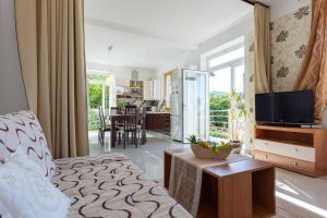 Una sala de estar con un sofá y un televisor en una habitación. en Villa Aska, en Lopud Island