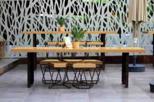 a table and chairs in a room with a wall at island in Pefki