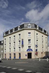 un gran edificio blanco en la esquina de una calle en Kyriad Hotel Lamballe, en Lamballe