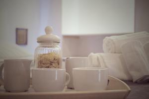 una bandeja con tazas y un frasco de cristal sobre una mesa en Puglia Loving Room, en Monopoli