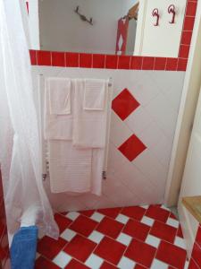 a bathroom with white towels and red and white tiles at A casa di Tommy B&B in Acireale