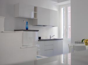 a white kitchen with white cabinets and a window at Cà dei Ciuà - Apartments for rent in Riomaggiore