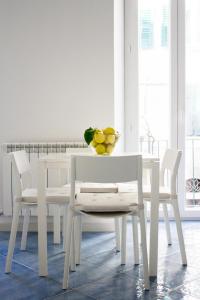 una mesa de comedor blanca y sillas con un bol de fruta. en Cà dei Ciuà - Apartments for rent, en Riomaggiore