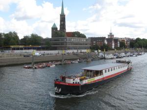 ein Boot, das einen Fluss hinunter in einer Stadt fährt in der Unterkunft Hotelboat Angeline in Amsterdam