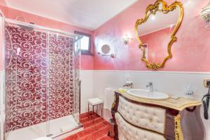 a bath room with a toilet, sink, mirror and bath tub at Hotel Sa Cheya Relais & Spa in Alghero