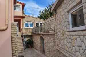 a stone house with a balcony on a building at Apartments Toska in Rab