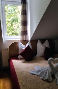 a bedroom with a couch with pillows and a window at Pensiunea Vila Gabriel in Sinaia