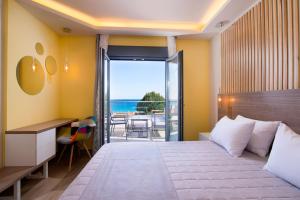 una camera con letto e vista sull'oceano di Semiramis Luxury Suites a Chrisi Ammoudia