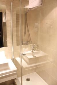 a bathroom with a sink, toilet and shower stall at Arc Elysées in Paris