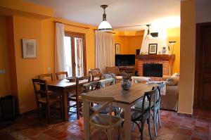 a dining room with a table and chairs and a living room at Casa Rural Estarrún in Aísa