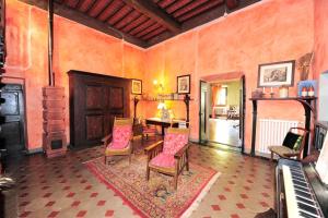 uma sala de estar com uma mesa e cadeiras e um piano em Villa Enrico Fermi em Rignano sullʼArno