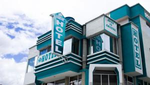 a blue and white building with a sign on it at Casa de Cristal Hotel in Chachagüí