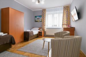 a small bedroom with a bed and a table and chair at Apartamenty Zielony przy MTP in Poznań
