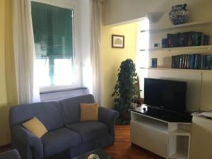a living room with a blue couch and a tv at Finestra su Genova - free parking in Genoa