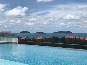 a swimming pool with a view of the ocean at Sunset Seaview Vacation Condos @ Infinity Avenue in Kota Kinabalu