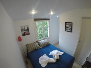Un dormitorio con una cama azul con dos cisnes. en Loft Palácio de Cristal, en Petrópolis