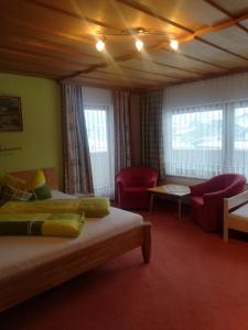 a hotel room with two beds and a couch at Ferienwohnung Bacher in Mayrhofen
