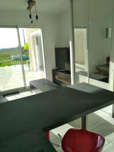 a living room with a table with a red chair at Plaisance du Touch in Plaisance-du-Touch