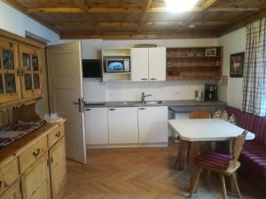 une cuisine avec des placards blancs et une table dans l'établissement Ferienwohnung Bacher, à Mayrhofen