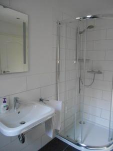 a white bathroom with a sink and a shower at Feriendomizil Steffen in Sankt Wendel
