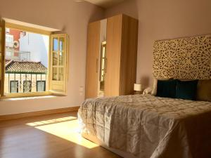 sypialnia z łóżkiem i dużym oknem w obiekcie NATURA SUITE MÁLAGA w Maladze