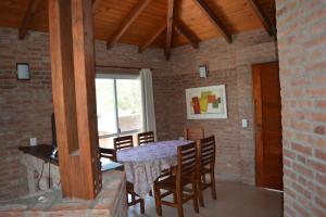 a dining room with a table and chairs at Cabañas Del Rio in Mina Clavero