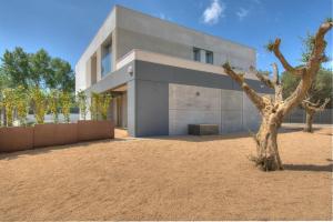 カレリャ・デ・パラフルジェリにあるModern Villa Olivera with Private Poolの木の前の建物