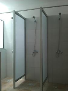 two glass shower doors in a bathroom with at Montevideo Chic Hostel in Montevideo