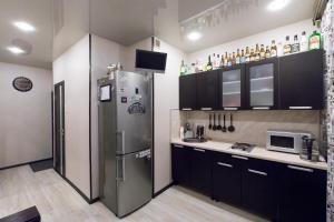キロフスクにあるElegant apartment Olimpiyskayaのキッチン(ステンレス製の冷蔵庫、黒いキャビネット付)