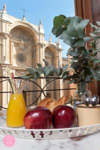 un plato de manzanas y un jarrón con una planta en Casa de la Catedral, en Granada