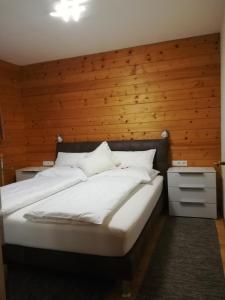 a bedroom with a large bed with a wooden wall at Apartement Gabi in Kleinlobming