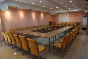 una sala de conferencias con una mesa larga y sillas en Hotel Villa Tafaj, en Tirana