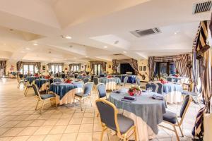 um salão de banquetes com mesas e cadeiras azuis em Marina Club Hotel em Baia Domizia