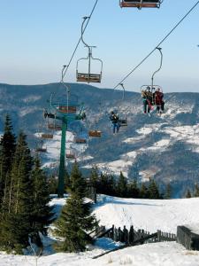 a group of people riding on a ski lift in the snow at Zielony Domek Wisłoczek in Rymanów