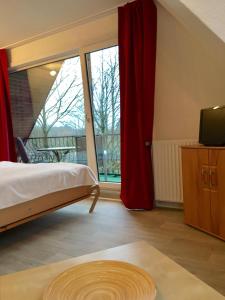 a bedroom with a bed and a large window at Haus Nicole in Cuxhaven